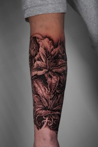 A stunning black and grey realism tattoo featuring intricately shaded lilies with delicate details, inked at Monochrome Tattoo Studio in Fresno, CA.