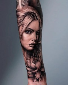 Hyper-realistic black and grey portrait tattoo of a woman with intricate shading and a lotus flower, done at Monochrome Tattoo Studio in Fresno, CA.